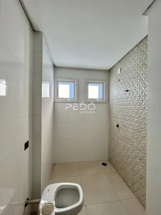 Foto de um banheiro interno com piso claro e paredes brancas.