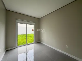 Sala de estar com porta de vidro que dá acesso ao jardim.