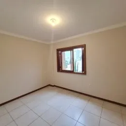 Foto interna de um cômodo com piso de cerâmica e janela.