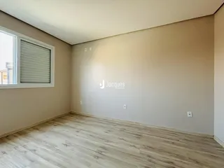 Uma sala com piso de madeira clara e paredes em tom neutro.
