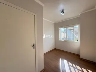 Ambiente interno com piso de madeira e janela iluminada.