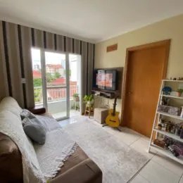 Sala de estar com sofá e janela de grande porte em um imóvel.