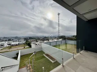Vista de um terraço com muro branco e área verde em Lajeado.