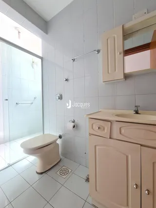 Foto de um banheiro com piso de cerâmica e box de vidro.