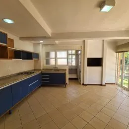 Cozinha com armários azuis e piso de cerâmica claro.