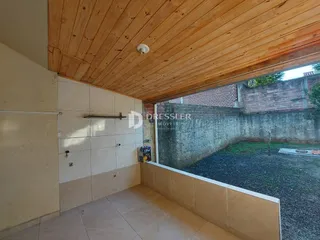 Vista interna de uma sala com piso de cerâmica e teto de madeira.