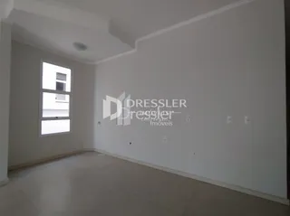 Ambiente interno de uma sala com paredes brancas e piso claro.