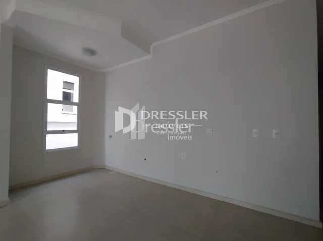 Ambiente interno de uma sala com paredes brancas e piso claro.