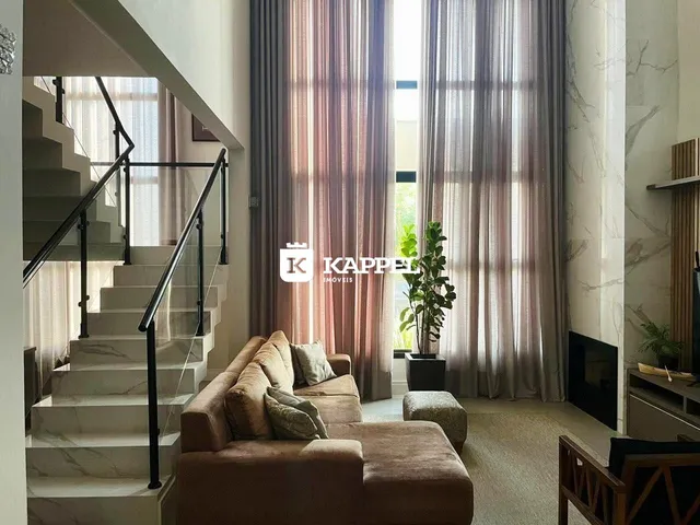 Sala de estar com sofá e escadaria em um apartamento em Lajeado.