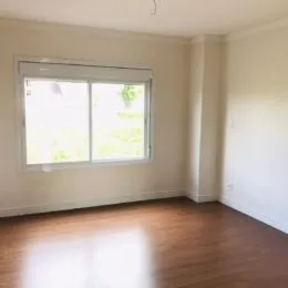 Foto de um cômodo interno com janela e piso de madeira.