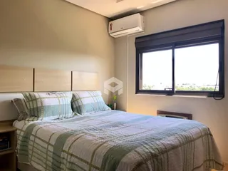 Quarto com cabeceira de madeira e janela grande.