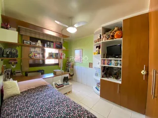 Quarto com cabeceira e estantes de madeira em um imóvel no Brasil.