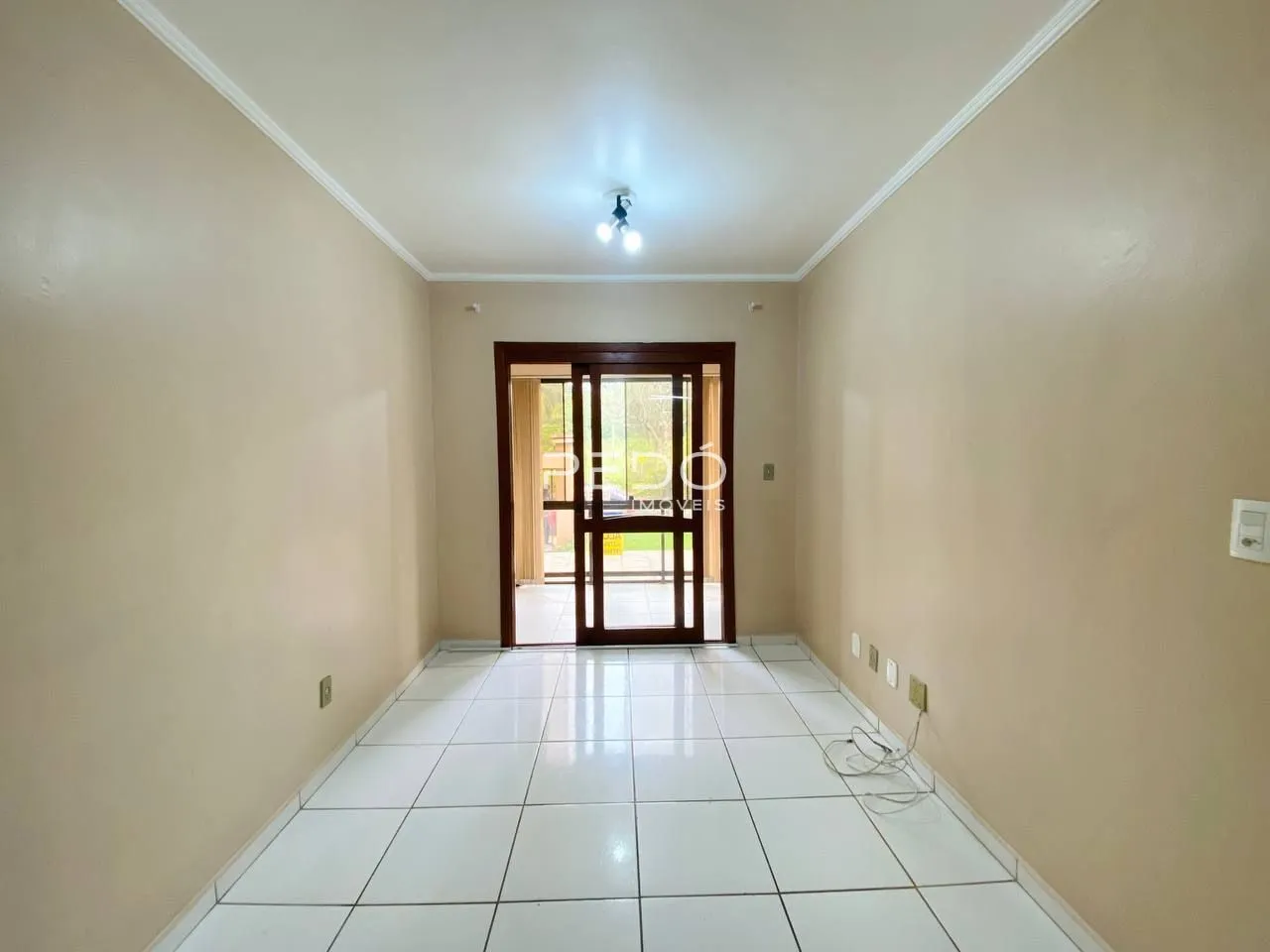 Corredor interno com piso de cerâmica e paredes claras.