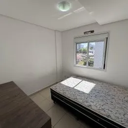 Quarto interno com parede branca e janela.