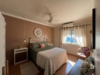 Foto de um quarto com cama e janela em uma residência.