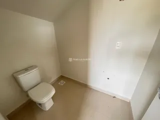 Foto de um banheiro mostrando um vaso sanitário branco.