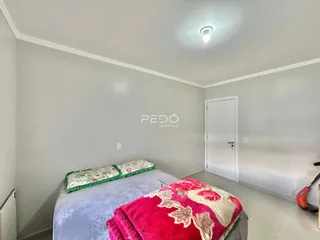 Quarto com cama e parede branca em um imóvel.