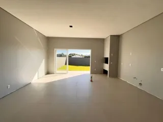 Vista interna de um ambiente amplo e vazio com paredes claras.