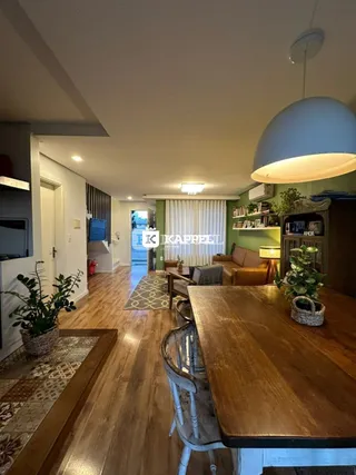 Sala de estar com piso de madeira e estantes visíveis.