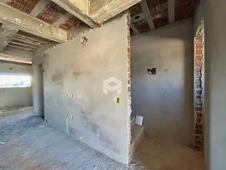 Foto de um ambiente interno em construção com paredes de alvenaria expostas.