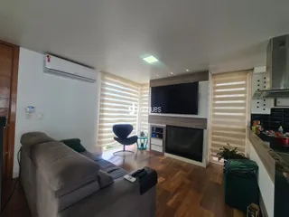 Sala de estar com piso de madeira e televisão na sala.