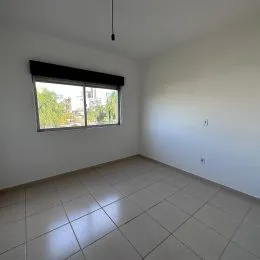 Sala de estar com piso de cerâmica e janela.