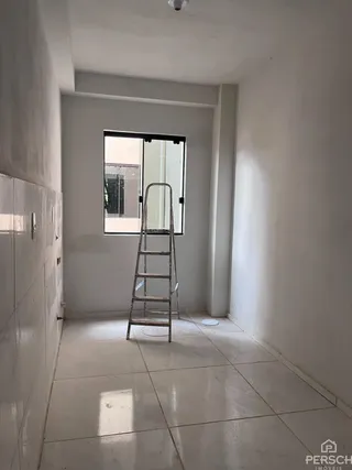Hall de entrada com piso claro e escada visível no interior da residência.