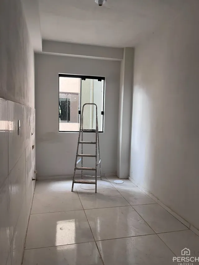 Hall de entrada com piso claro e escada visível no interior da residência.