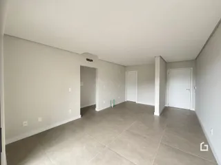 Vista de um corredor interno com piso de cerâmica e portas brancas.