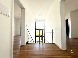Hall de entrada com piso de madeira clara.