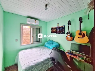 Quarto com cama e janela em um ambiente de cores claras.