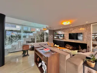 Sala de estar moderna com lareira e acesso a uma área externa por porta de vidro.