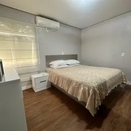 Quarto com cama e ar-condicionado em um imóvel.
