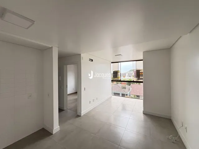 Vista interna de um corredor com piso de cerâmica e paredes brancas.
