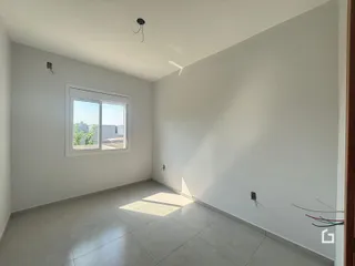 Ambiente interno de uma sala com piso de cerâmica e janela.