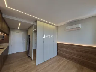 Ambiente interno com piso de madeira e armários embutidos em um imóvel.