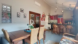 Foto de uma sala de jantar com mesa de madeira e cadeiras em um imóvel no Brasil.