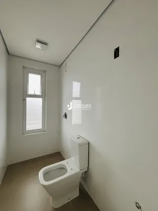 Banheiro com janela e piso claro.