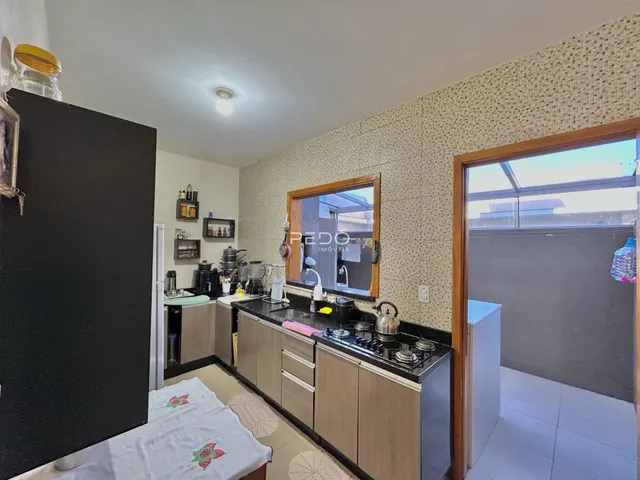 Vista da cozinha com armários e bancadas em madeira.