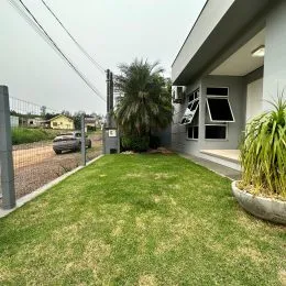 Gramado verde adjacente à fachada da residência.