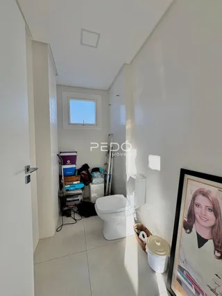 Vista de um corredor interno com um vaso sanitário branco.