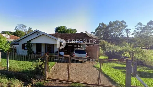 Fachada de uma residência em Lajeado, Brasil, com cerca e jardim na frente.