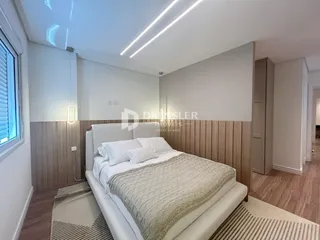 Quarto com cama e painel de madeira na parede.