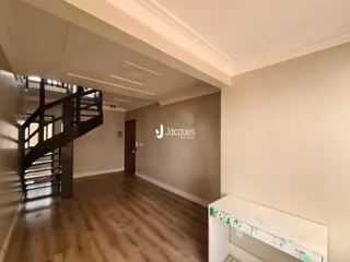 Hall com piso de madeira e escadaria em uma propriedade.