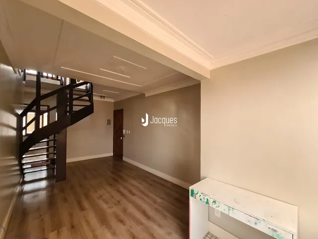 Hall com piso de madeira e escadaria em uma propriedade.