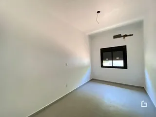 Vista interna de um ambiente com paredes brancas e piso claro.