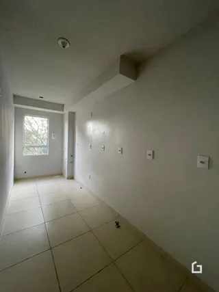 Hall de corredor interno com piso de cerâmica clara.