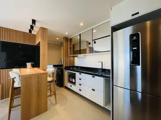 Cozinha moderna com armários de madeira e bancadas escuras.