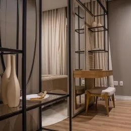 Foto de um interior com estrutura metálica escura e cortinas claras.