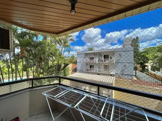 Vista da varanda com vegetação tropical e outro edifício.